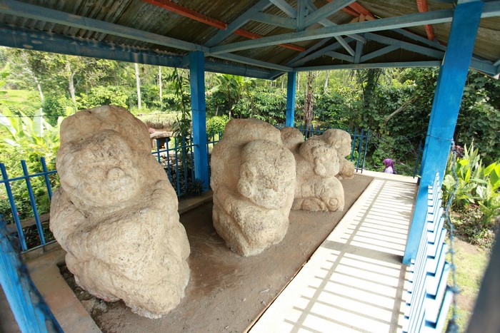 Ancient stone statues under a shelter