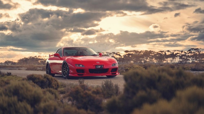 Red Mazda RX-7 FD sports car at sunset