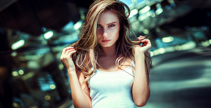 Model with blonde hair in a white tank top