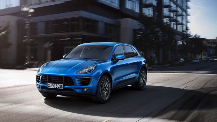 Blue Porsche Macan driving on a city street