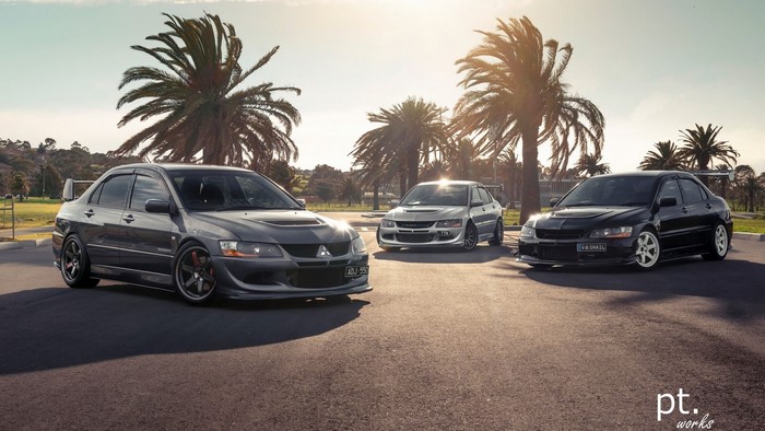 Three Mitsubishi Lancer Evolution cars parked outdoors