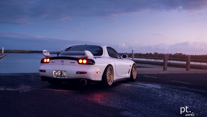 White Mazda RX-7 FD sports car at dusk by the water