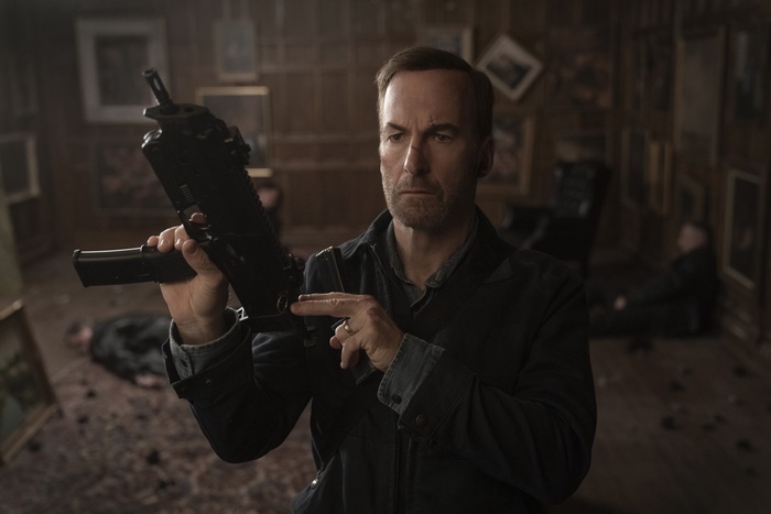 Bob Odenkirk holds a submachine gun in Nobody