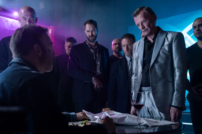 Bob Odenkirk and men in a dimly lit room