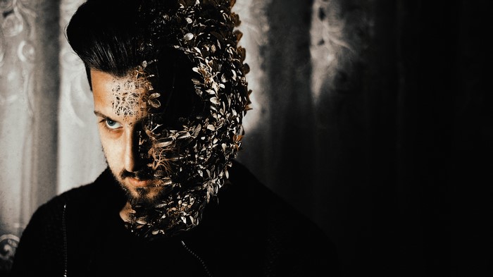 Man with half face covered in leaves