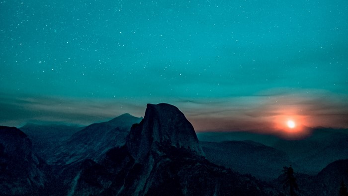 Half Dome mountain under starry sky with sunset