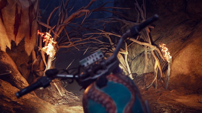Motorcycle handlebars in a dark cave with torches