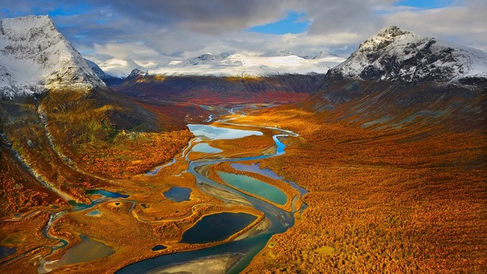 Autumn valley with river and snowy mountains in Sarek National Park