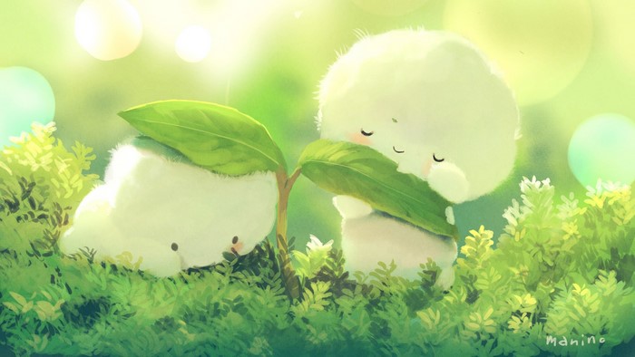 Two fluffy creatures under a leaf in grass
