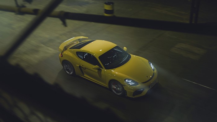 Yellow Porsche 718 Cayman driving with motion blur