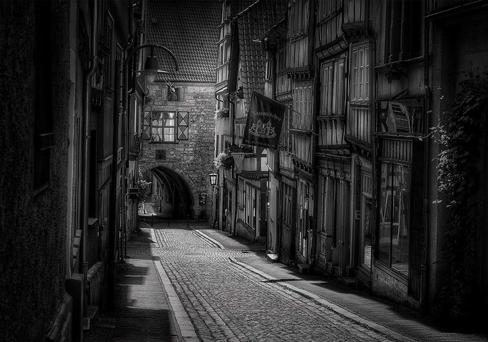 Monochrome street with old buildings and archway