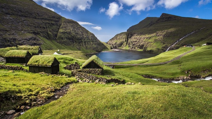 Faroe Islands village with turf-roofed houses and lake
