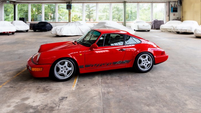 Red Porsche 911 Carrera RS parked in a garage