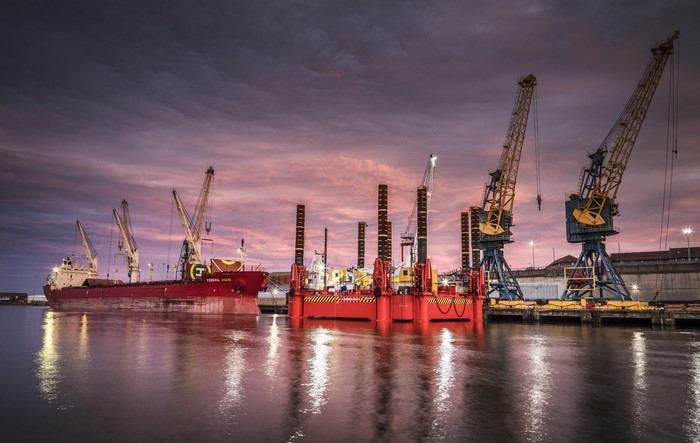 Ship and cranes in a harbor at sunset