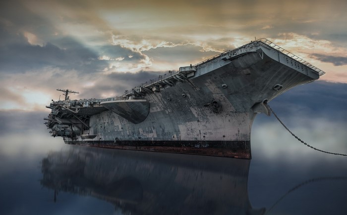 An abandoned aircraft carrier, USS John F. Kennedy, floats on the water