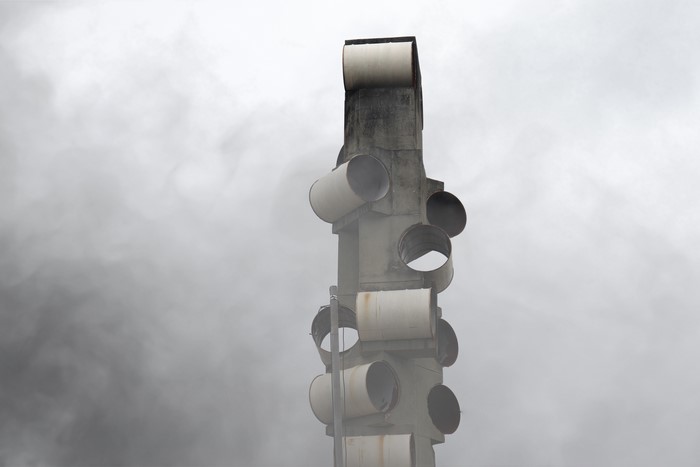 Concrete structure with pipes against cloudy sky