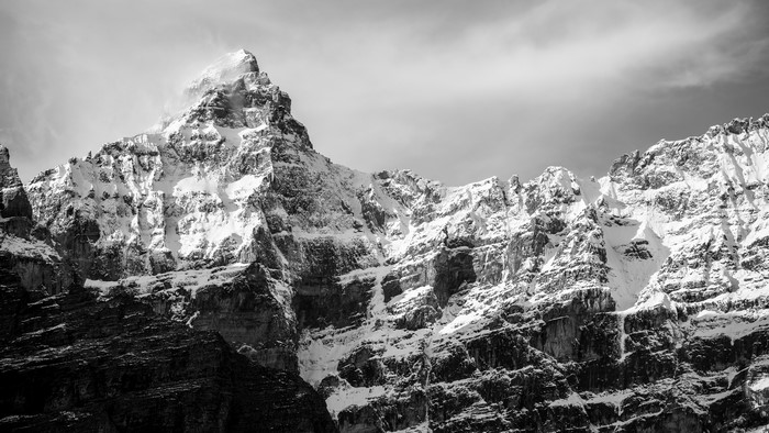 Snow-covered rocky mountains under a cloudy sky
