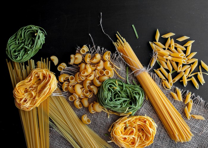 Assortment of dry pasta on a dark surface