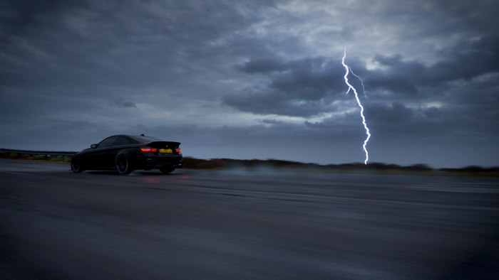 Black BMW M4 drifting during a lightning storm in Forza Horizon 4