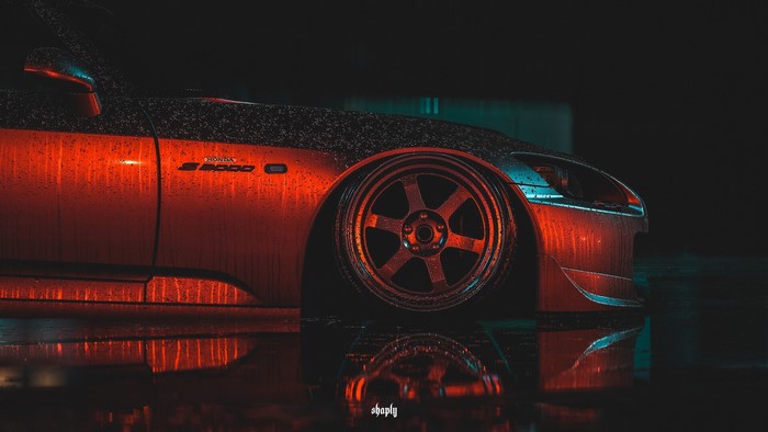 Red Honda S2000 with custom wheels in rain
