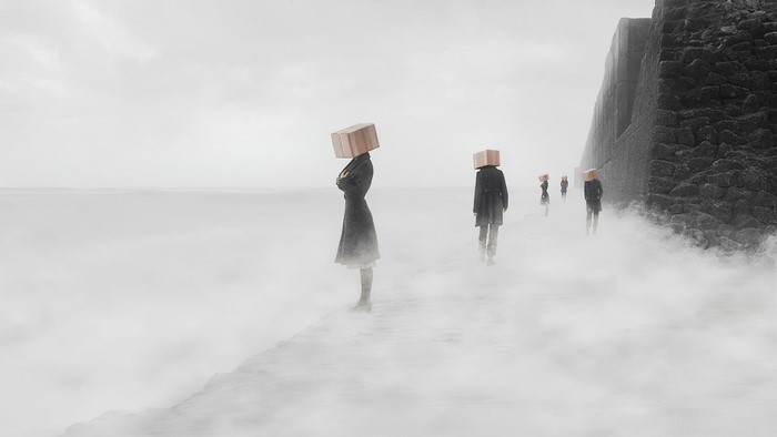 People with boxes on heads walk along a foggy coast
