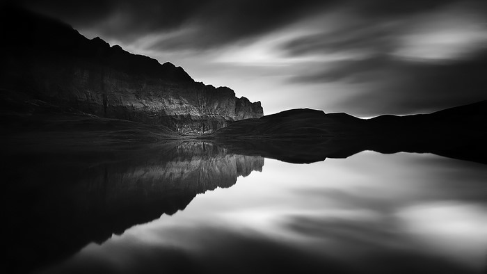 Monochrome mountain reflection in dark water