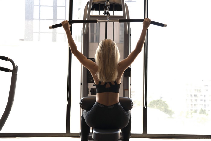 Woman exercising on a lat pulldown machine
