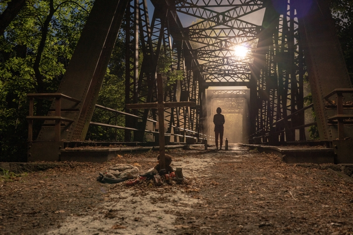 Emily Blunt on a bridge with a cross