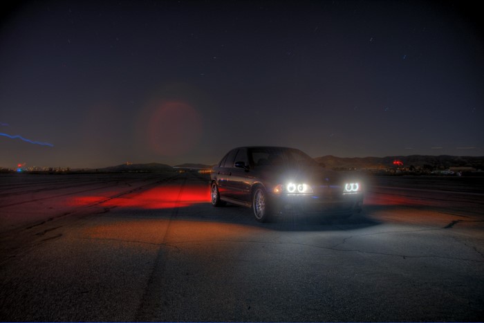 BMW E39 sedan at night with headlights on