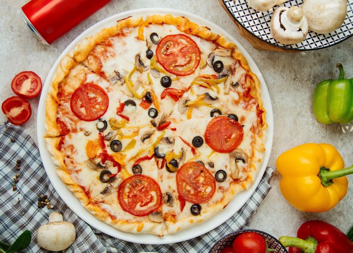 Pizza with tomatoes, mushrooms, olives, and peppers
