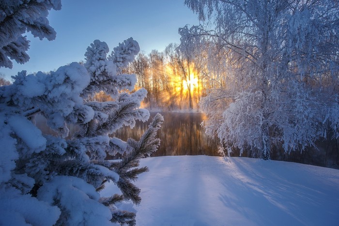 Winter sunrise over a frozen river in Russia