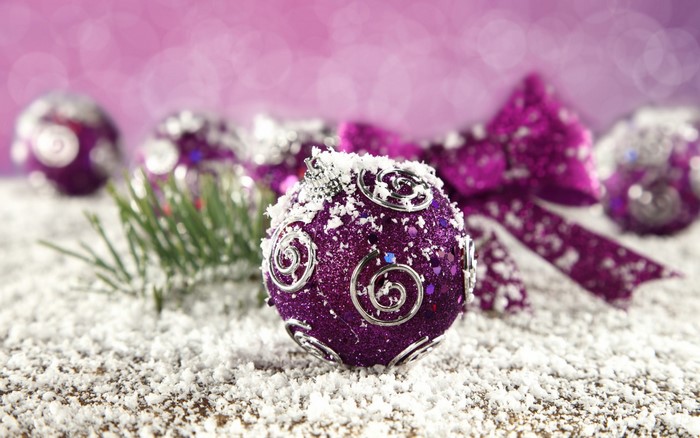 Purple Christmas ornaments with snow and pine needles