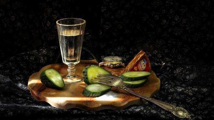 Still life with vodka, cucumbers, cheese, and watch