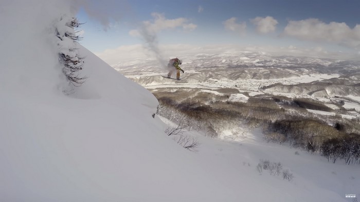 Snowboarder jumps off a snowy cliff in Japan