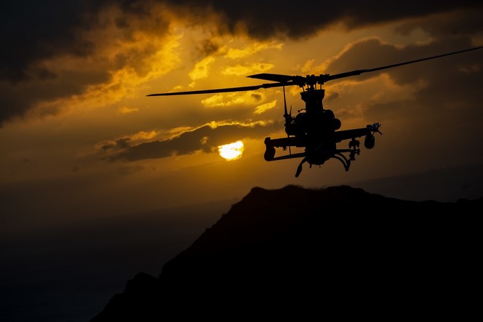AH-1Z Viper helicopter flying at sunset over mountains