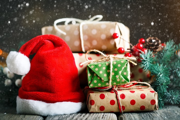 Christmas presents and Santa hat on wooden table