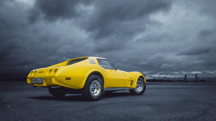 Yellow Chevrolet Corvette C3 on a cloudy day