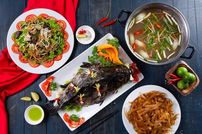 Asian seafood meal with fish, soup, and salad