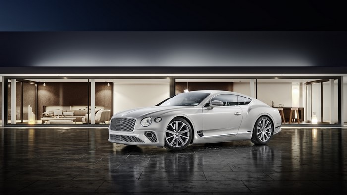 Silver Bentley Continental GT parked in front of a modern house