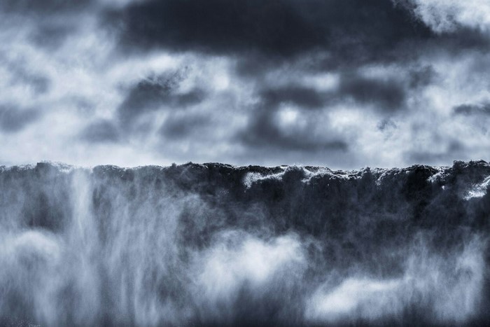 Waterfall mist against dark clouds