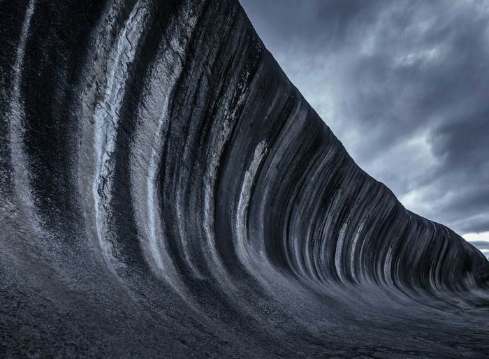 Wave Rock formation under cloudy sky