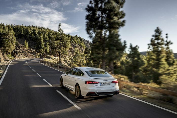 White Audi RS5 driving on a mountain road