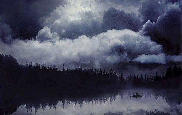 Dark clouds over a misty lake and forest
