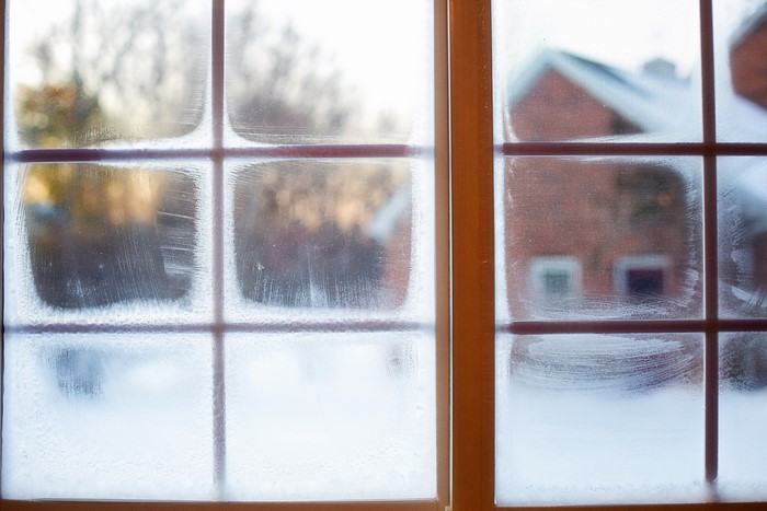 Frosty window pane with winter scene outside