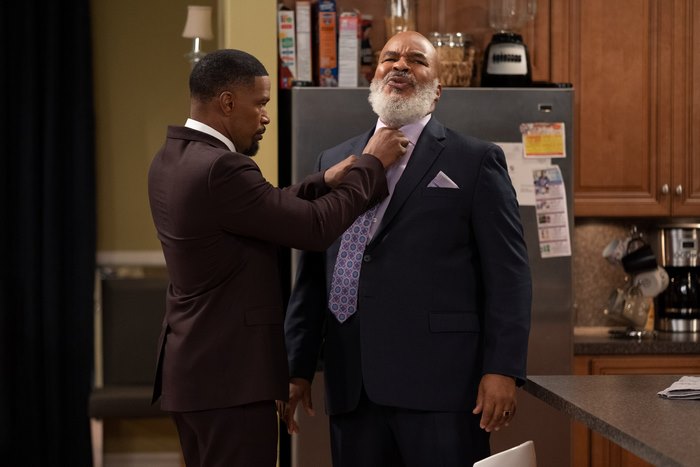 Jamie Foxx adjusting a man's tie