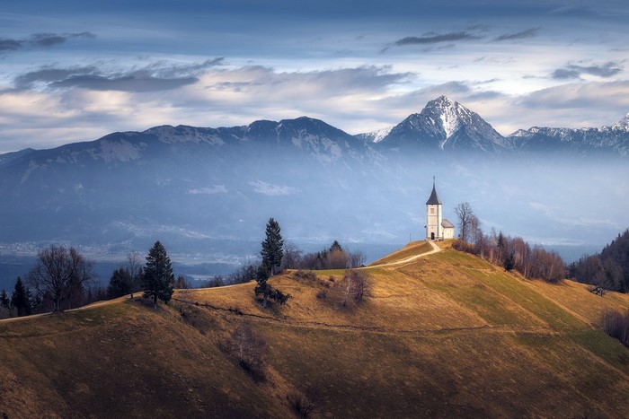 Church on a hill with mountains in the background