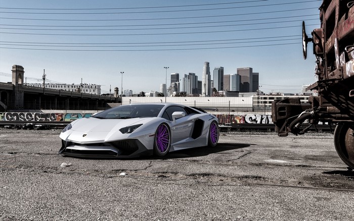 White Lamborghini Aventador with purple rims in urban setting