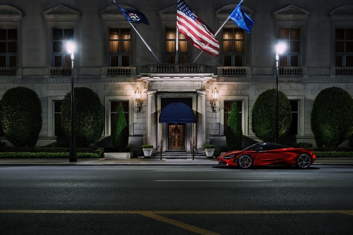 Red McLaren 720S parked in front of Detroit Athletic Club at night