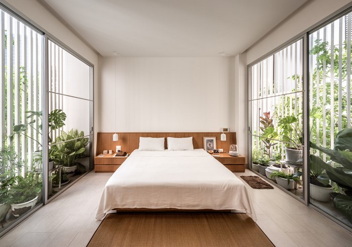 Modern bedroom with plants and large windows