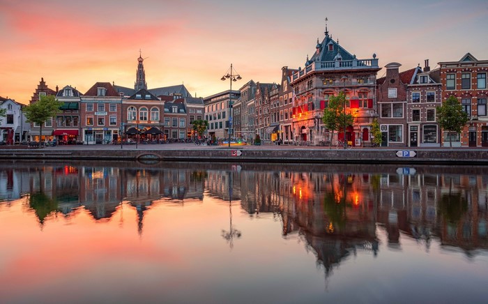 Cityscape with canal reflection at sunset in the Netherlands